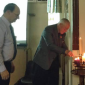 Fr Denis and David Arnold light a candle each in commemoration of some of the Holocausts remembered during the evening.